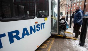 woman in wheelchair boarding Winnipeg bus via handi-transit ramp